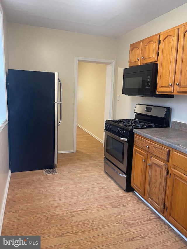 kitchen featuring stainless steel appliances and light hardwood / wood-style flooring