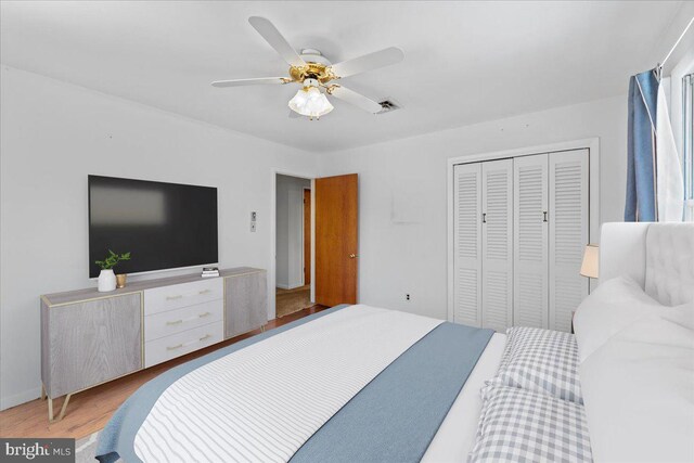 bedroom with hardwood / wood-style flooring, ceiling fan, and a closet