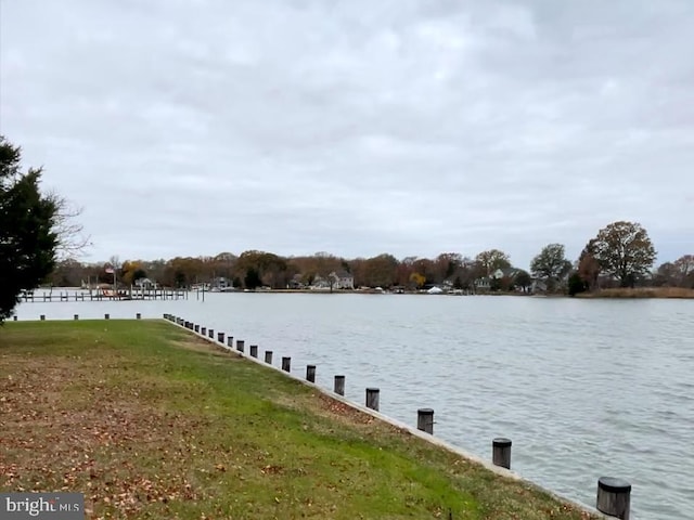 view of dock featuring a water view and a lawn