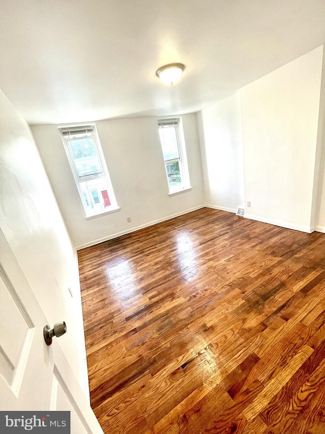 unfurnished room with wood-type flooring