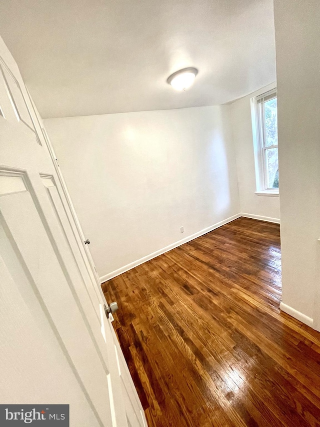 unfurnished room with dark wood-type flooring