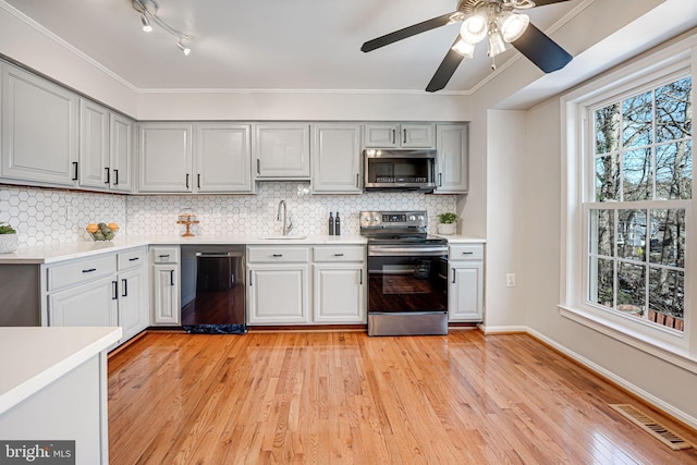 kitchen featuring sink, plenty of natural light, gray cabinets, and appliances with stainless steel finishes