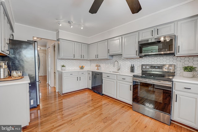 kitchen featuring crown molding, appliances with stainless steel finishes, sink, and gray cabinetry