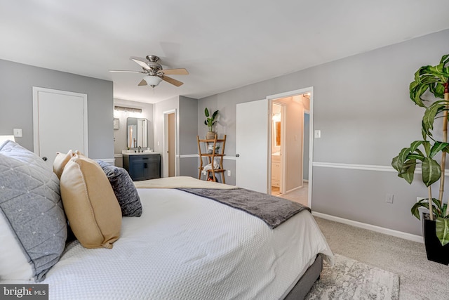 bedroom featuring light carpet, ceiling fan, and ensuite bathroom