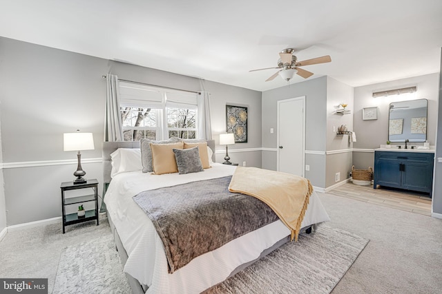 bedroom featuring sink, light colored carpet, and ceiling fan