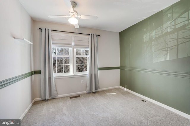 spare room featuring carpet and ceiling fan