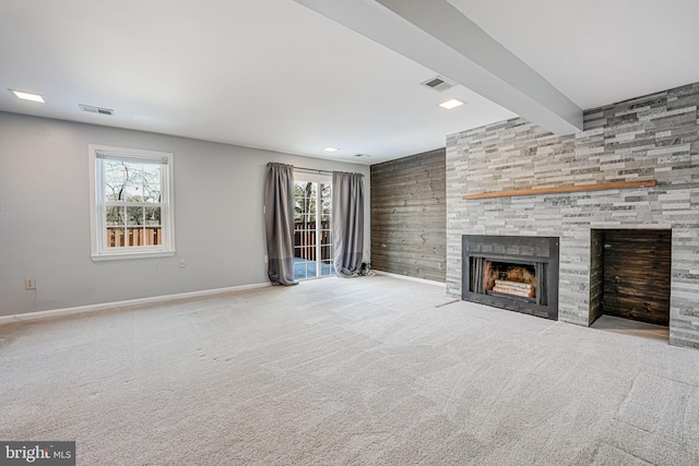 unfurnished living room featuring beamed ceiling, light colored carpet, and a fireplace