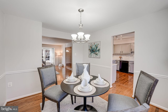 dining room with an inviting chandelier and light hardwood / wood-style flooring