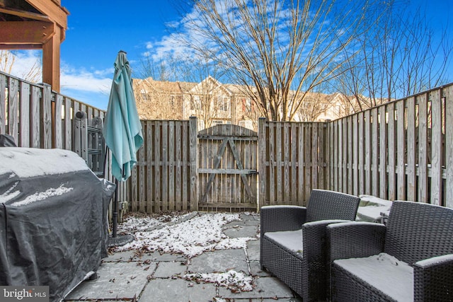 snow covered patio with a grill