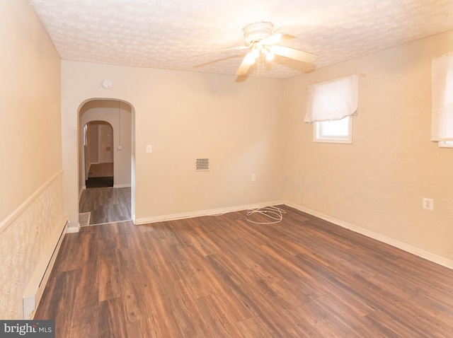 spare room with ceiling fan, dark hardwood / wood-style flooring, a textured ceiling, and a baseboard radiator