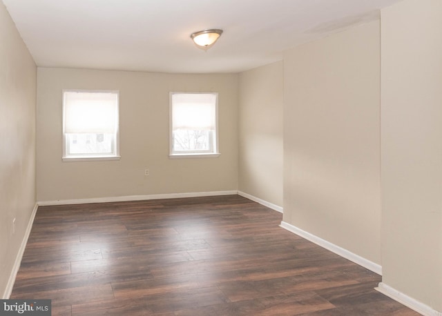 empty room with plenty of natural light and dark wood-type flooring