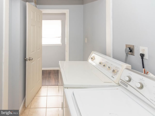 laundry room with washing machine and clothes dryer and light tile patterned floors