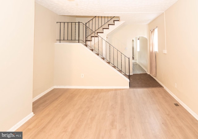 stairs with wood-type flooring and a textured ceiling