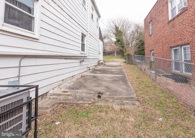 view of side of property with central AC unit and a patio area