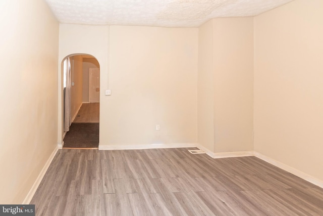 spare room with hardwood / wood-style floors and a textured ceiling