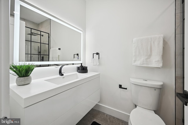 bathroom with tile patterned floors, a shower with door, vanity, and toilet