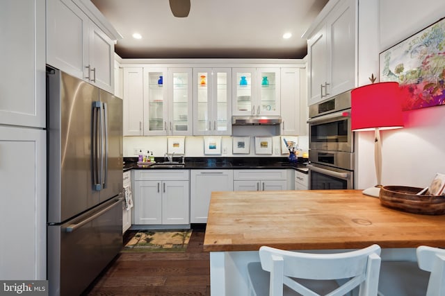 kitchen featuring appliances with stainless steel finishes, wood counters, dark hardwood / wood-style floors, sink, and white cabinetry