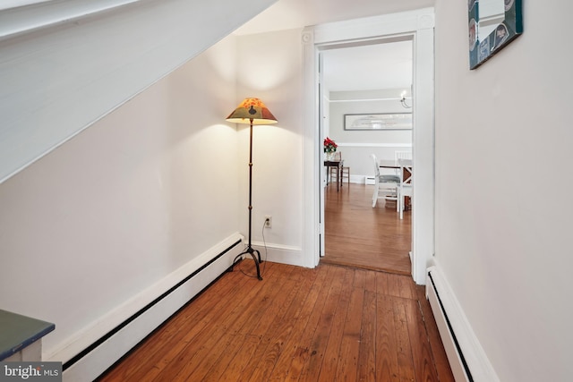 corridor featuring baseboard heating and wood-type flooring