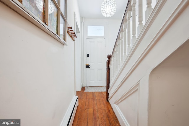 hallway featuring an inviting chandelier and hardwood / wood-style floors