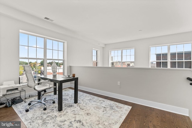 office area with dark hardwood / wood-style floors and plenty of natural light