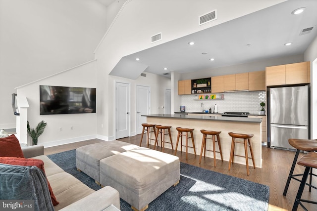 living room featuring dark hardwood / wood-style flooring, ornamental molding, and sink