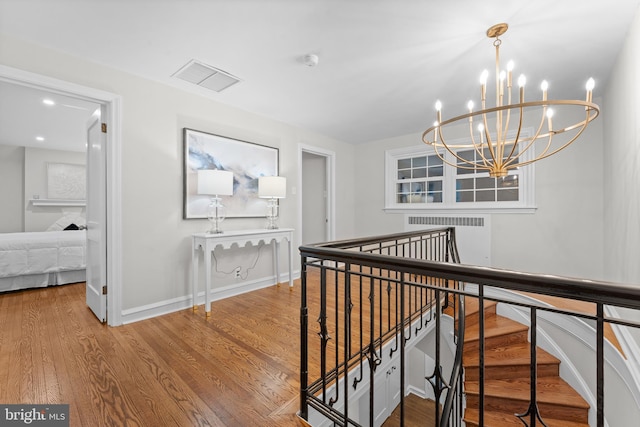 hall with hardwood / wood-style flooring and a notable chandelier