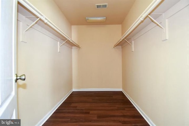 walk in closet with dark wood-type flooring