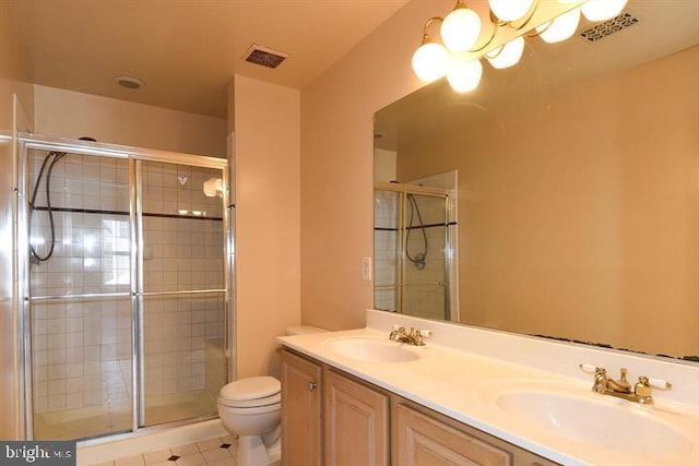 bathroom featuring tile patterned flooring, vanity, toilet, and an enclosed shower