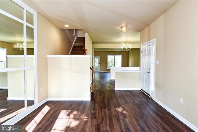 spare room featuring dark hardwood / wood-style flooring and an inviting chandelier