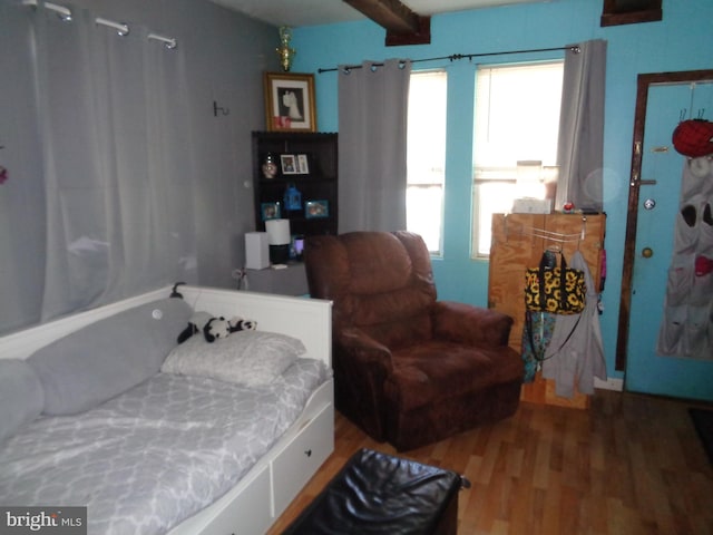 bedroom featuring beam ceiling and wood-type flooring