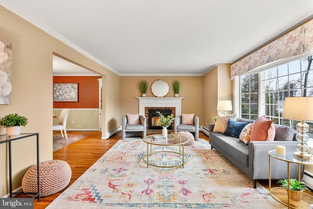 living room with a fireplace, a baseboard heating unit, crown molding, and wood-type flooring