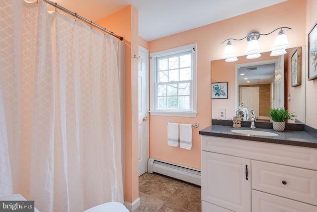 bathroom featuring baseboard heating and vanity