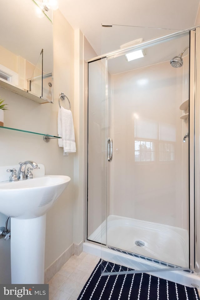 bathroom featuring sink, walk in shower, and tile patterned floors