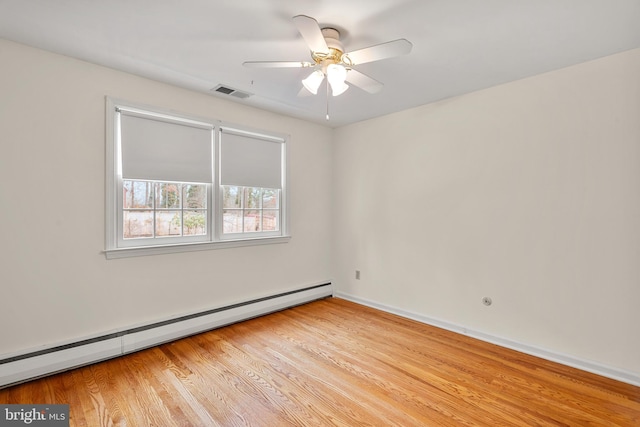 empty room featuring a baseboard heating unit, ceiling fan, and light hardwood / wood-style floors