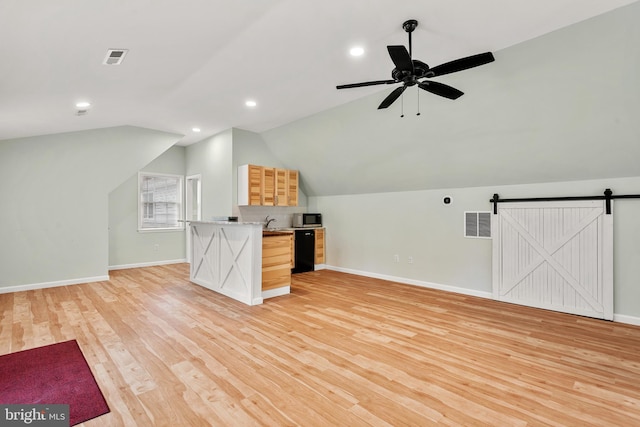 bonus room featuring a barn door, light hardwood / wood-style floors, ceiling fan, sink, and lofted ceiling