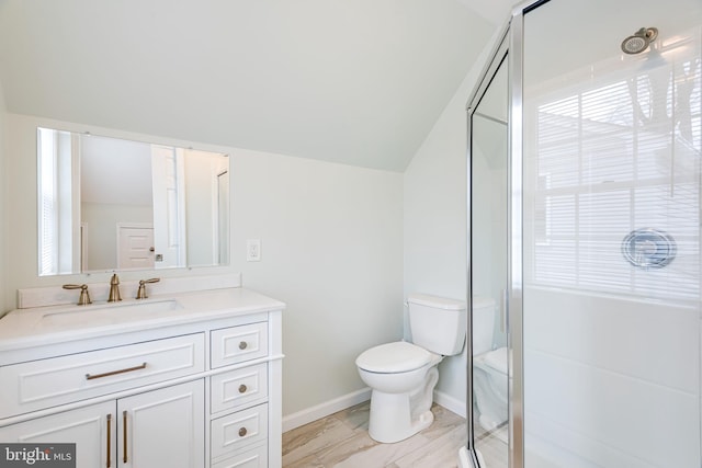 bathroom featuring toilet, vanity, a shower with shower door, and vaulted ceiling