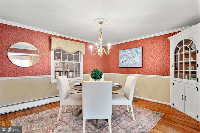 dining area featuring a baseboard heating unit, a chandelier, hardwood / wood-style floors, and crown molding