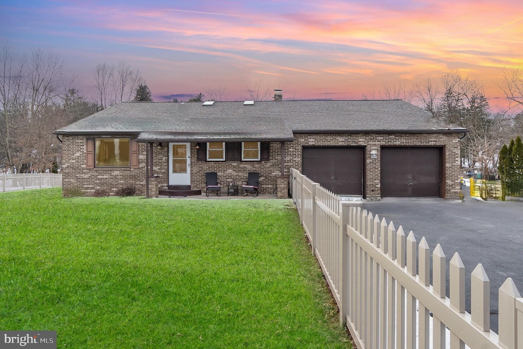 view of front facade with a garage and a lawn