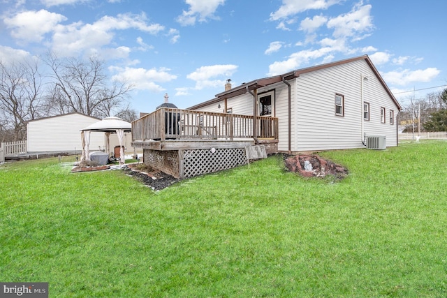 rear view of house with a lawn, cooling unit, a deck, and a gazebo