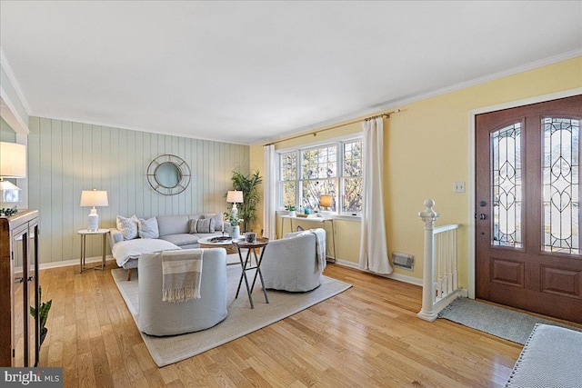 living room featuring wooden walls, light hardwood / wood-style floors, and ornamental molding