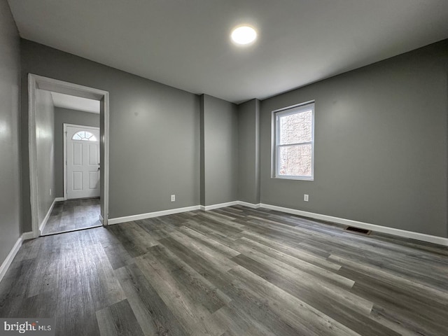 spare room with dark wood-type flooring