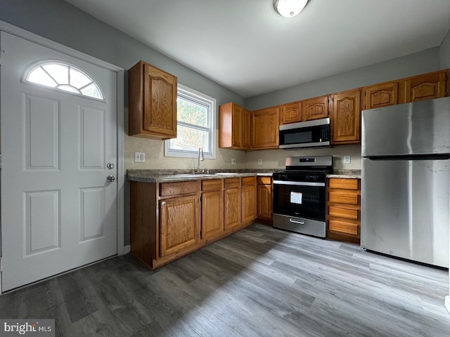 kitchen with sink, wood-type flooring, and appliances with stainless steel finishes