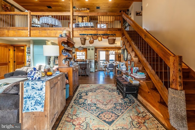 living room with hardwood / wood-style floors, a towering ceiling, and wood ceiling