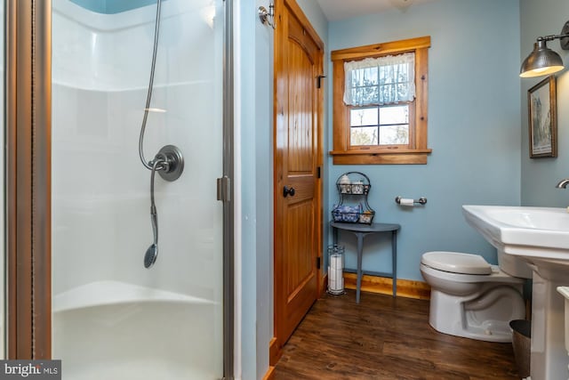 bathroom featuring hardwood / wood-style floors, toilet, and an enclosed shower