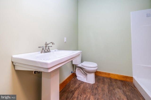 bathroom with hardwood / wood-style flooring and toilet