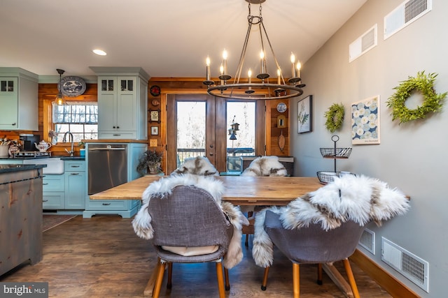 dining area with a notable chandelier, sink, and dark wood-type flooring