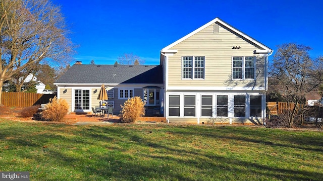 rear view of property featuring a yard and a patio area