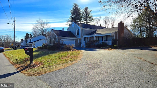 view of front facade featuring a porch, a garage, and a front lawn