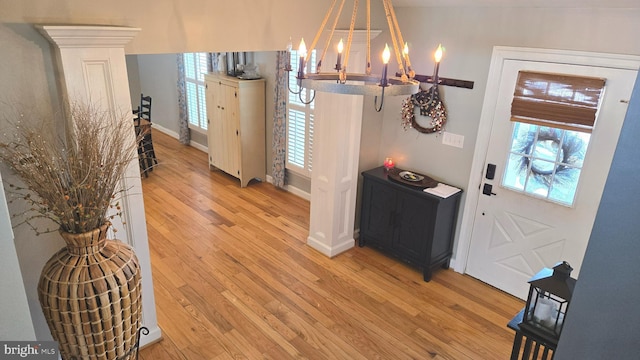 foyer entrance with light hardwood / wood-style flooring and an inviting chandelier