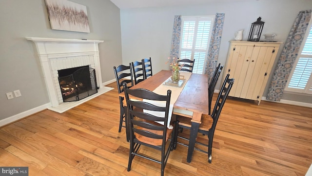 dining space featuring a fireplace and light hardwood / wood-style floors